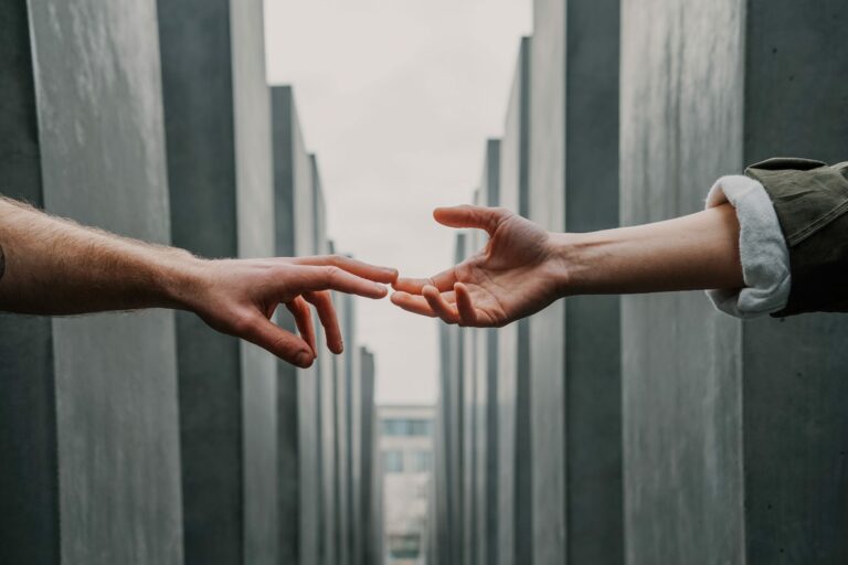 two hands meet across a gap between walls