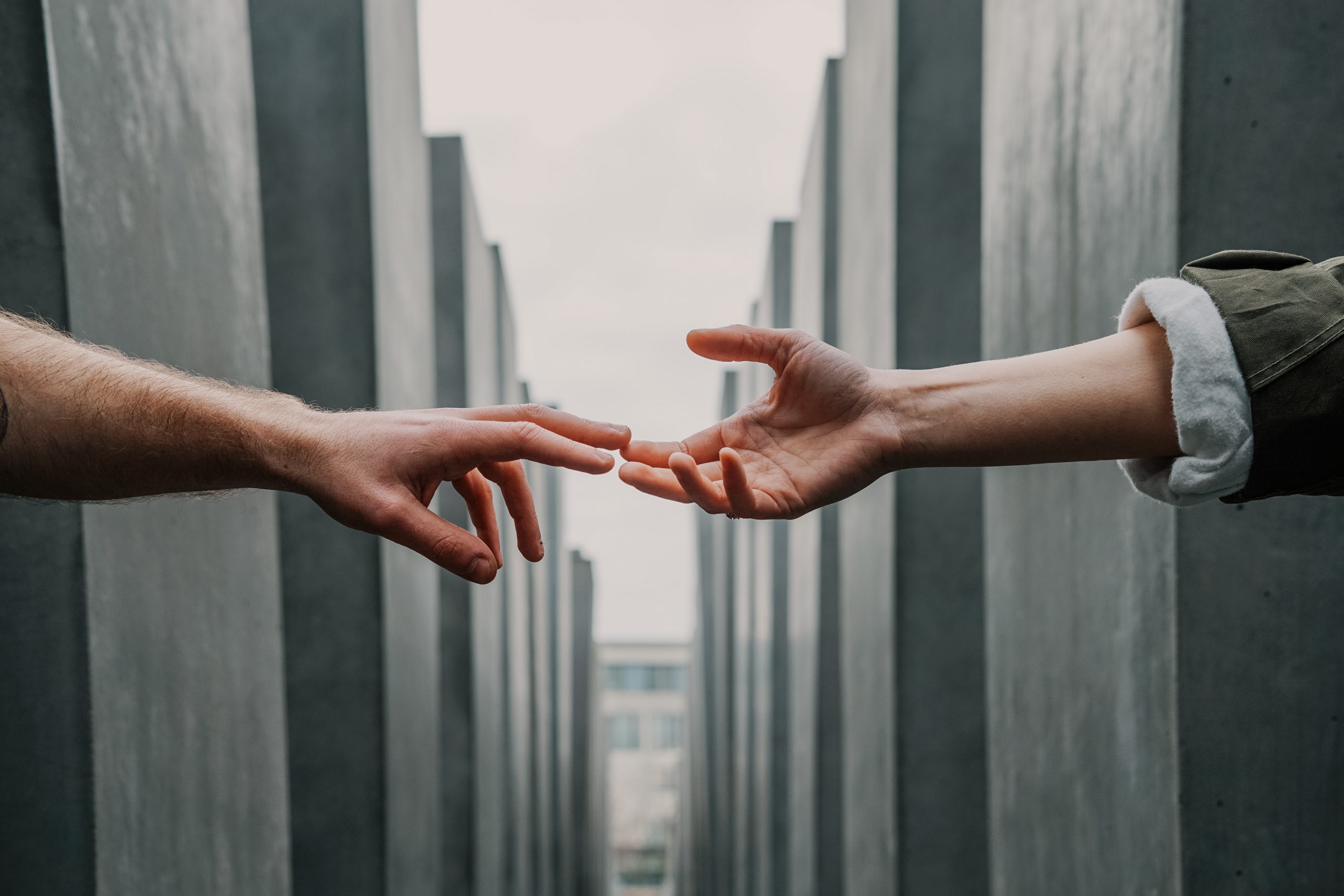 two hands meet across a gap between walls